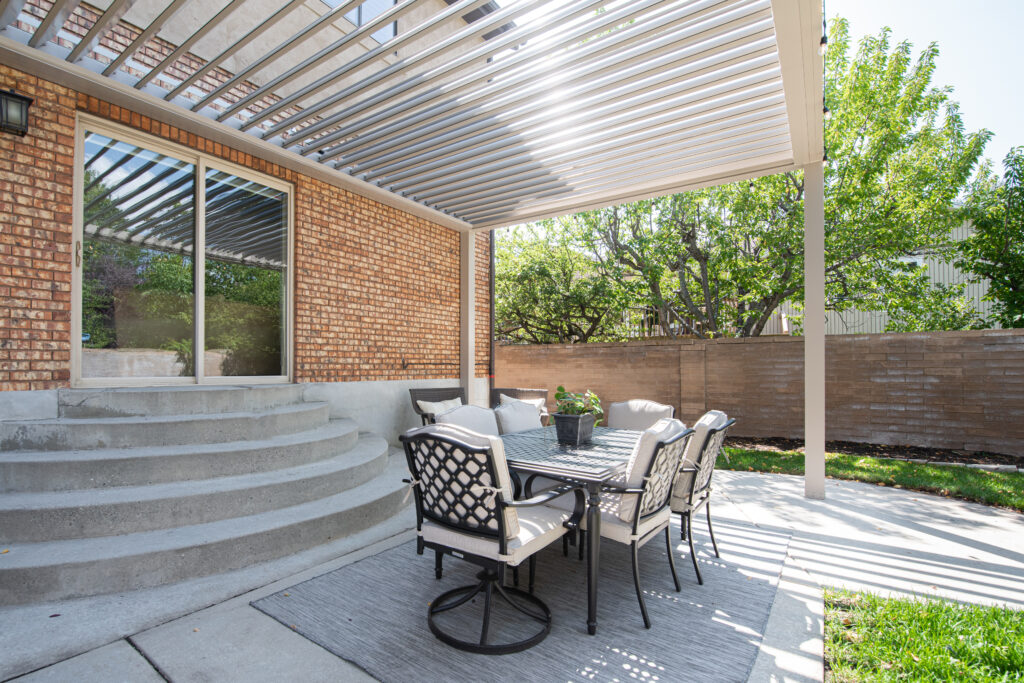 picture of tan sundance louvered pergola with louvers open next to home