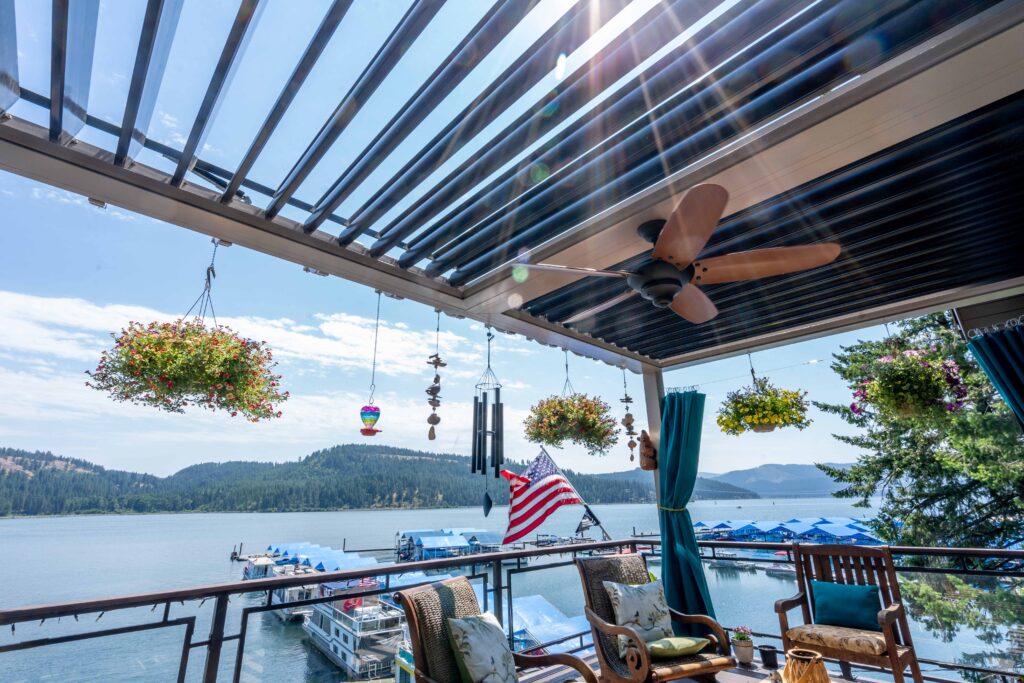 picture of a tan sundance louvered pergola with black louvers and fan beam viewing over a lake