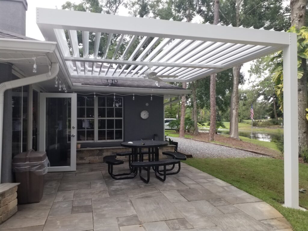 picture of a white louvered pergola with white louvers open and a fan beam mounted