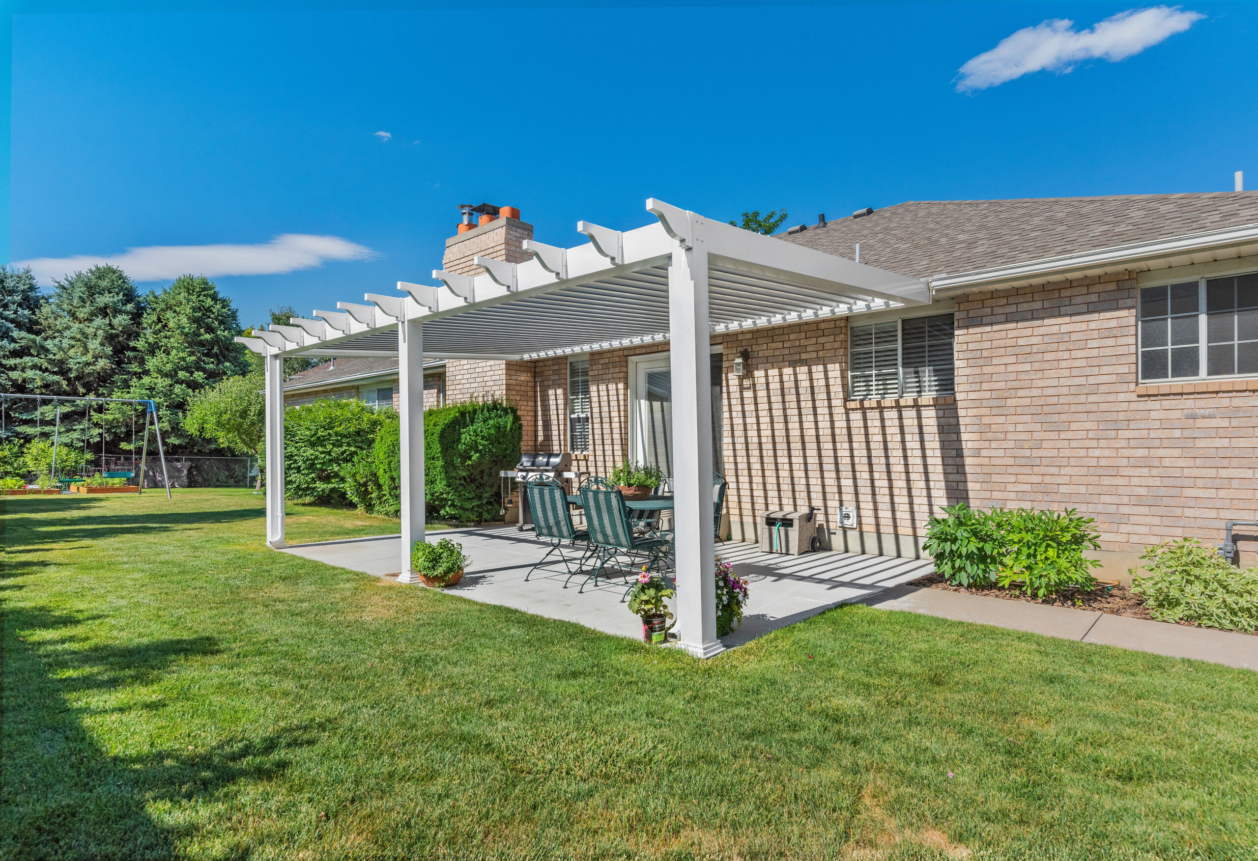 Sundance louvered pergola with decorative pergola cuts over a backyard patio